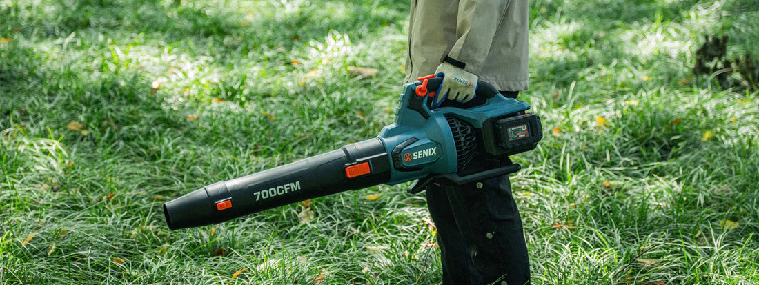 Person using Senix 40V cordless leaf blower with 700 CFM in grassy outdoor area