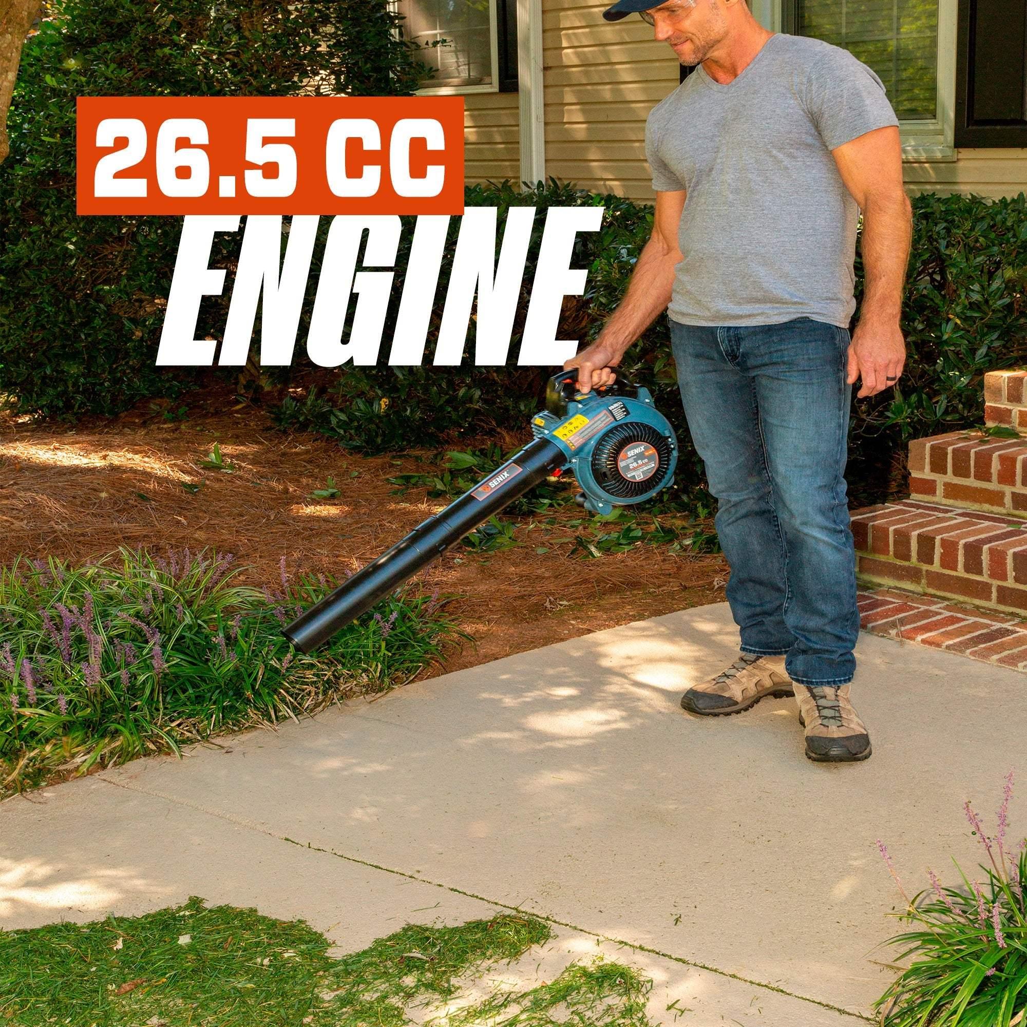 Man using a Senix 26.5 CC engine leaf blower on a residential sidewalk with garden and porch
